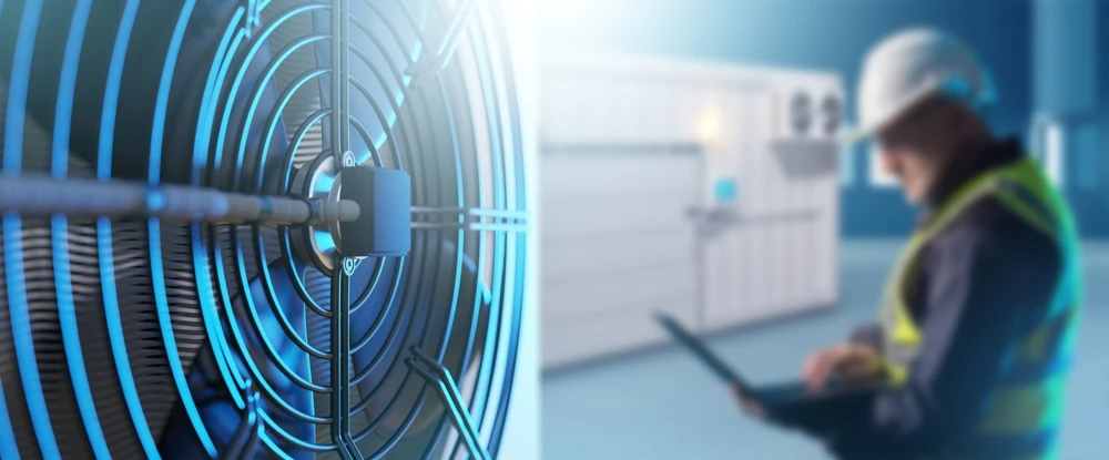 Close-up of an industrial cooling fan with a technician inspecting HVAC equipment – Keeping It Cool The Evolution Of Air Conditioning