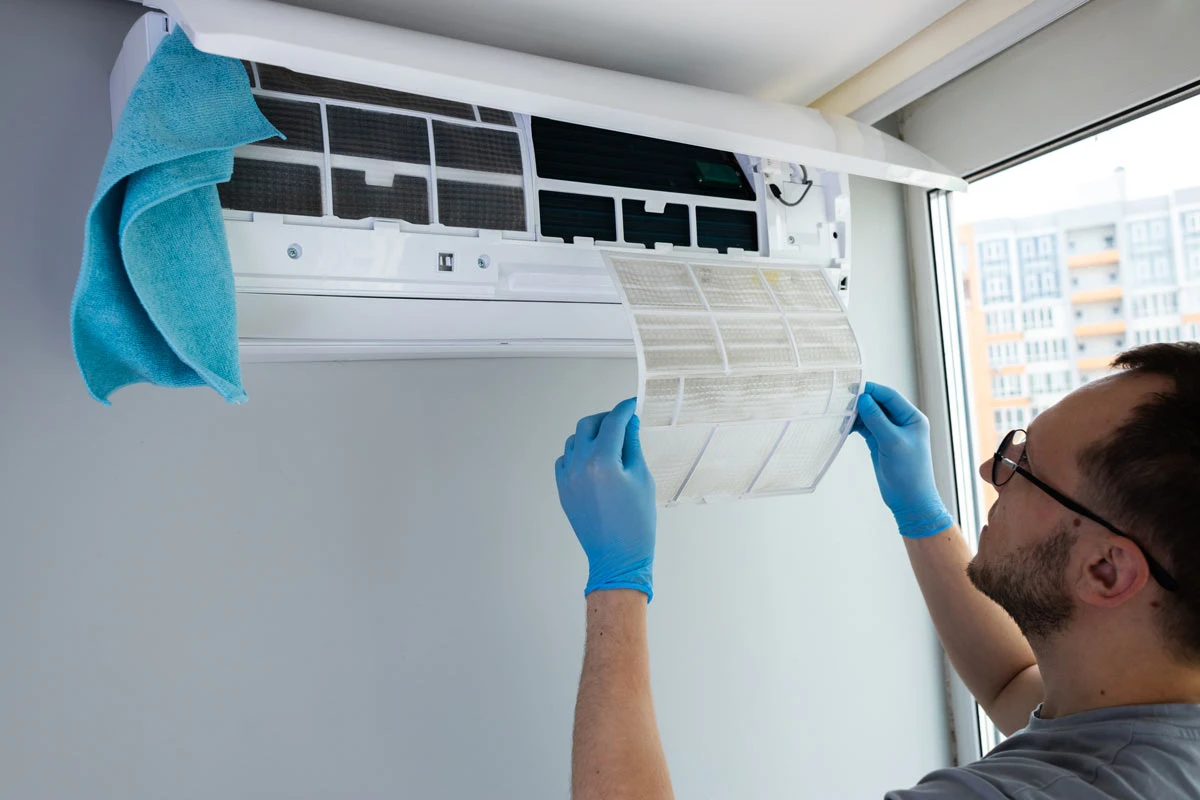 Technician cleaning an AC filter at home to improve airflow and indoor air quality Cleaning Air Ducts Make A Difference