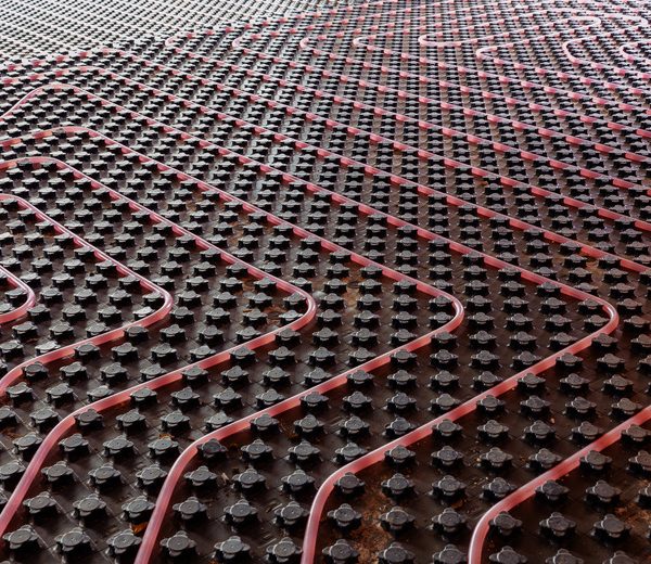 Underfloor heating system installation. Close up on water floor heating system interior of a new residential building. Pipes filled with propylene glycol. Individual Heating.