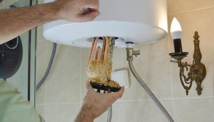 plumber-taking-out-old-water-heater-with-scale-deposition-from-boiler-bathroom_1048944-5971262